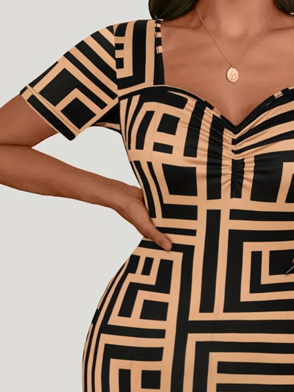 Black and beige geometric patterned dress on a plain background