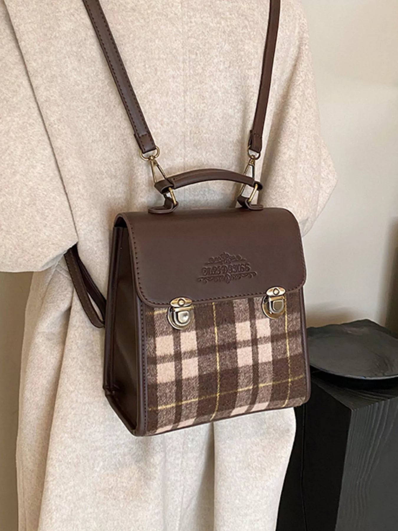 Brown plaid handbag with a matching strap on a light background