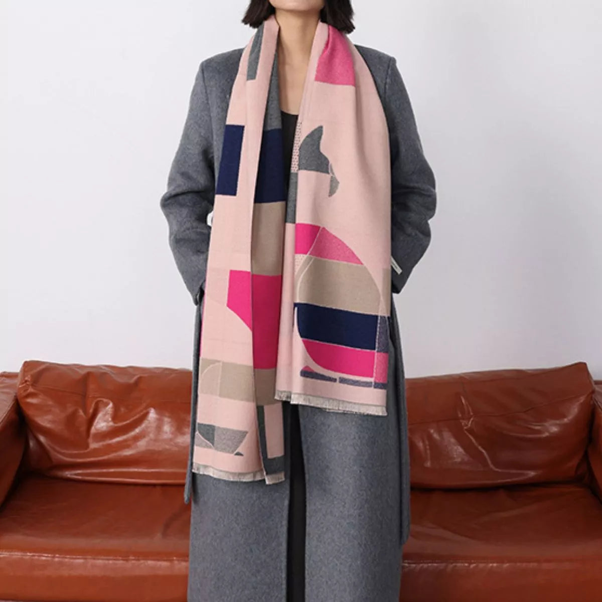 Model wearing a patterned scarf with a red couch in the background
