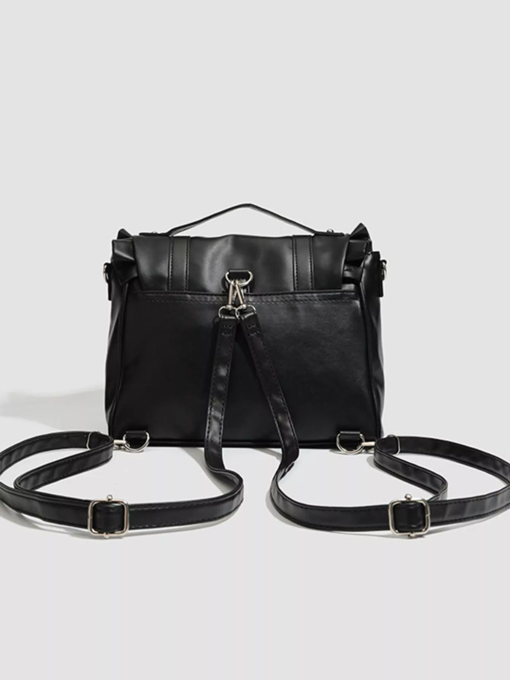 Black leather backpack with multiple straps on a light gray background