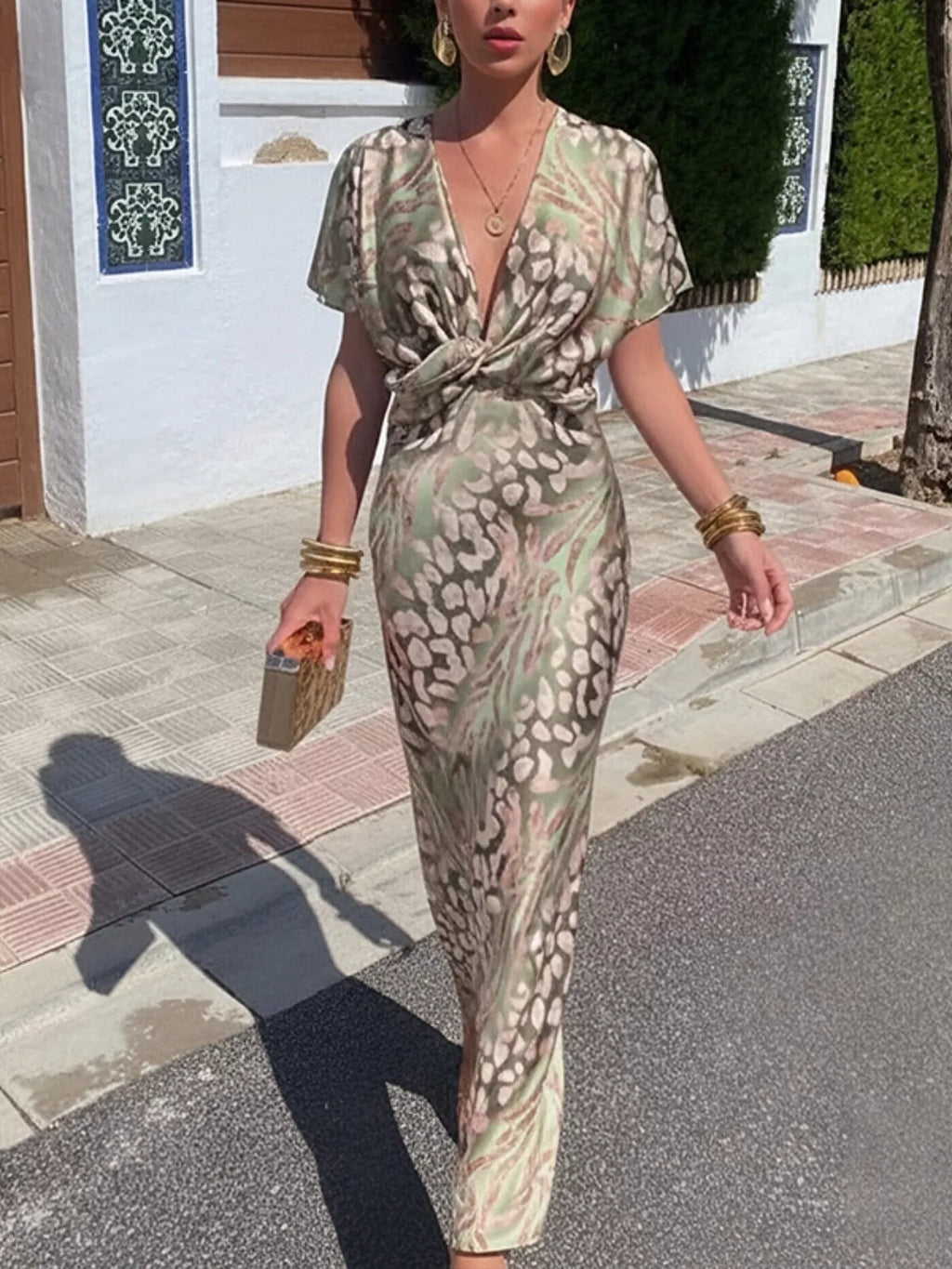 Woman in a patterned dress walking on a street.
