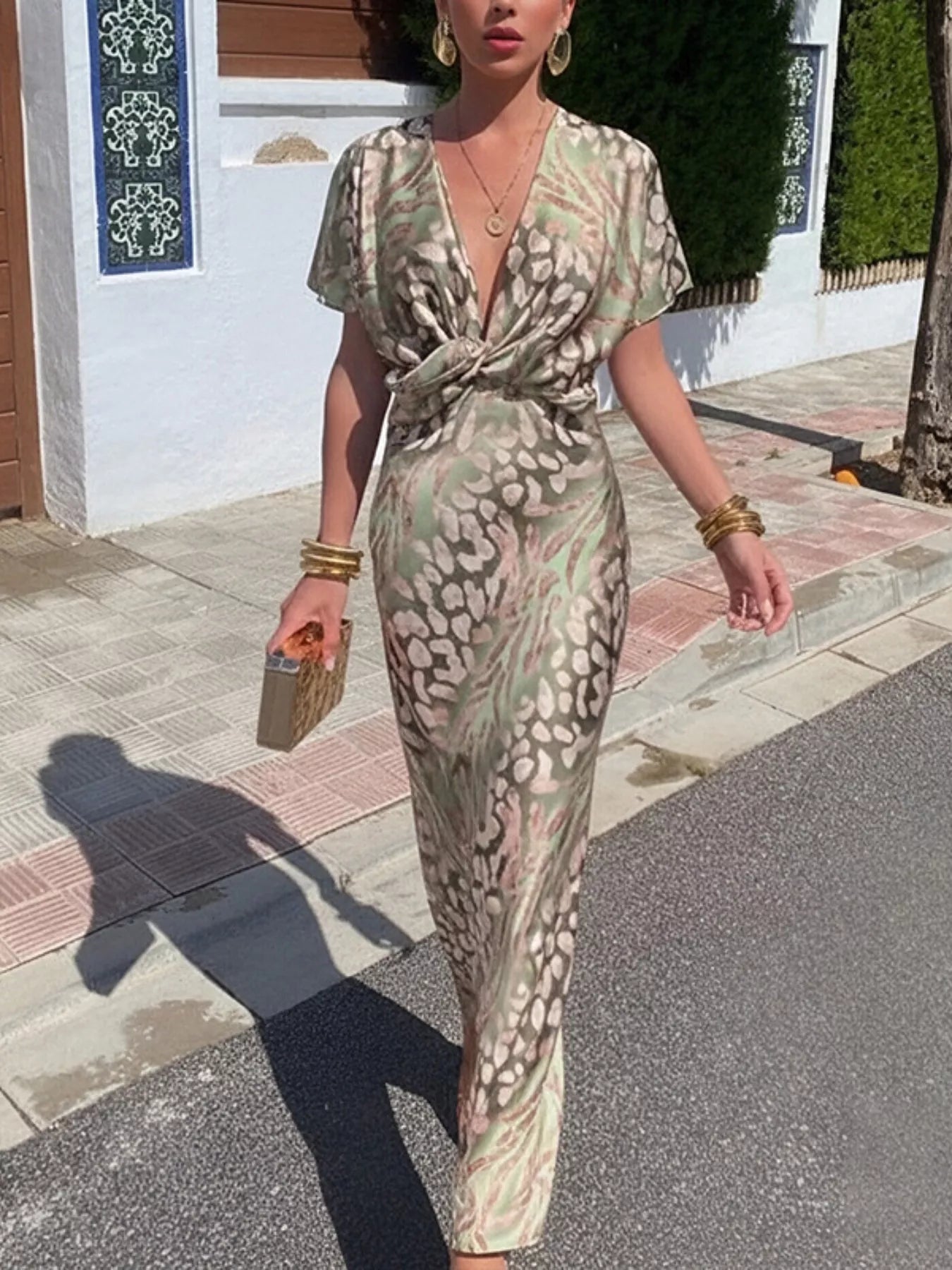 Woman in a patterned dress walking on a street.