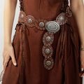 Brown dress with decorative belt featuring silver concho details.