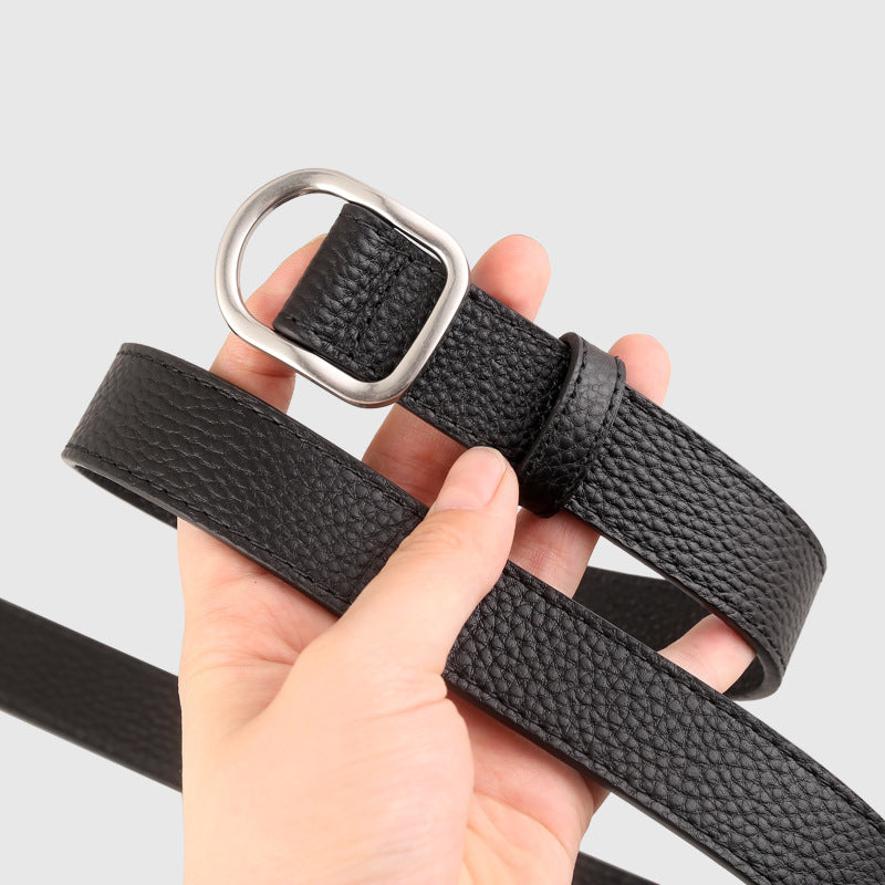 Black belt with silver buckle held by a hand on a light gray background