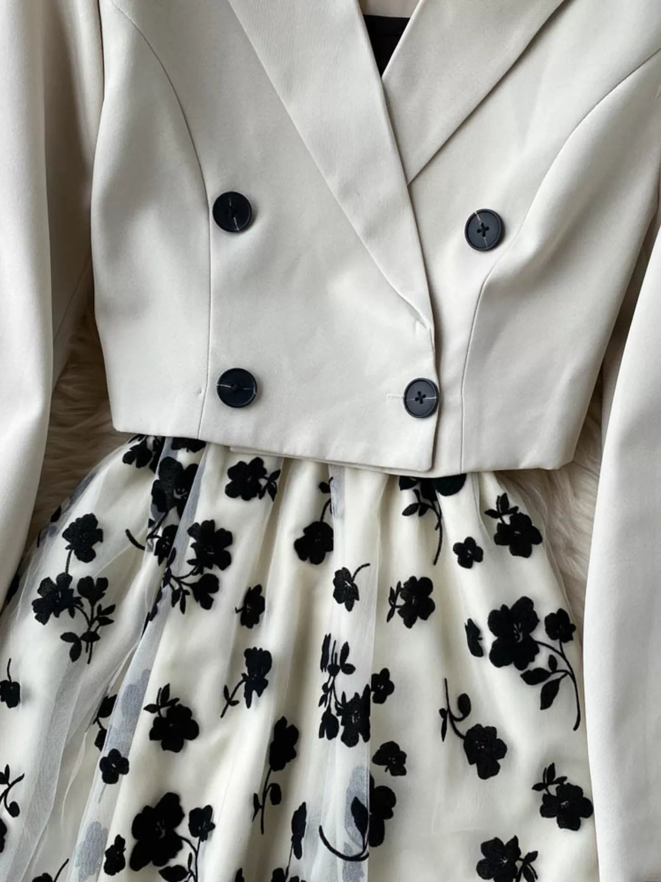 White coat with black floral dress underneath