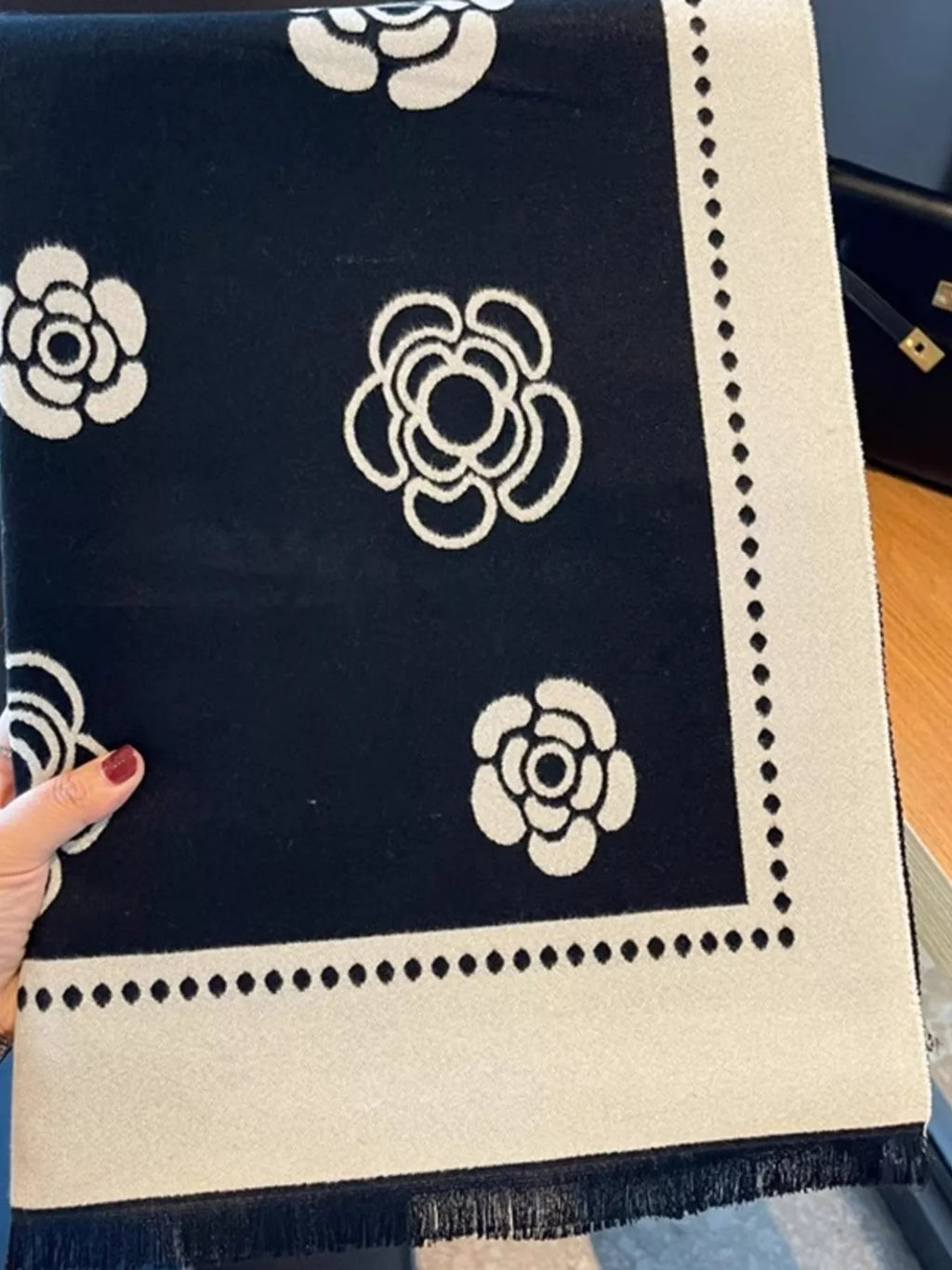 Navy blue fabric with white floral patterns held by a hand.