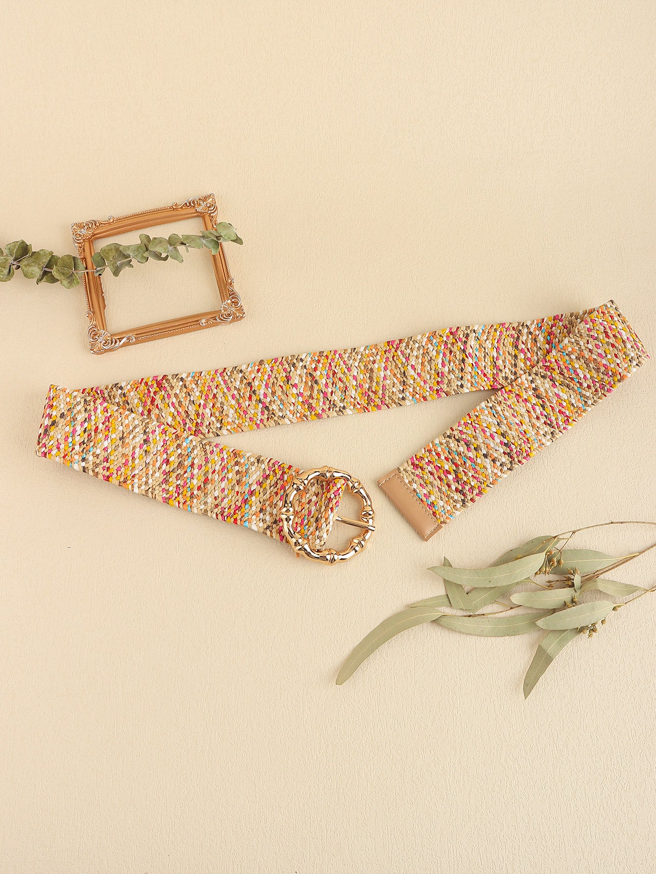 Colorful woven belt on a beige background with decorative elements.