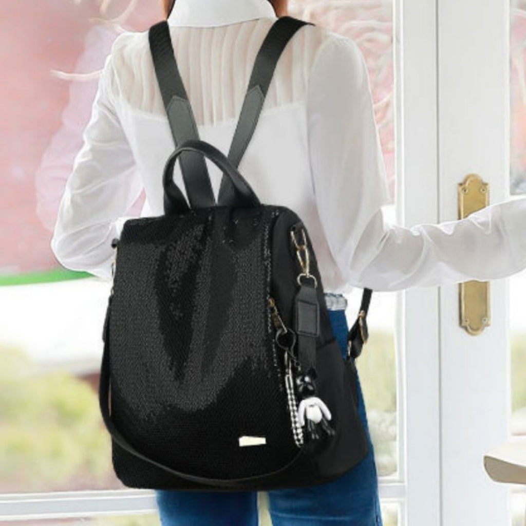 Model wearing a black backpack with a blurred background