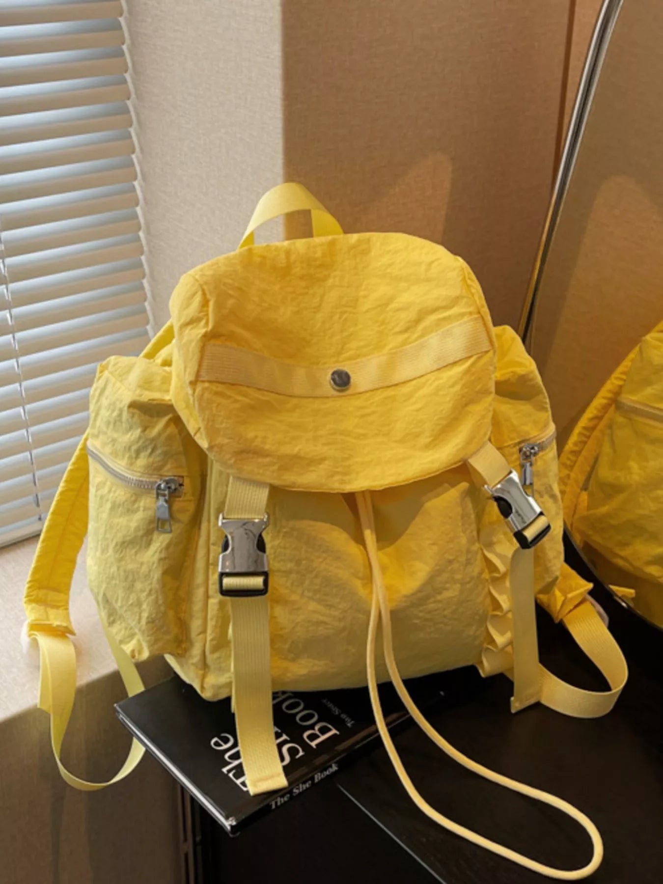 Yellow backpack on a black surface with a neutral background