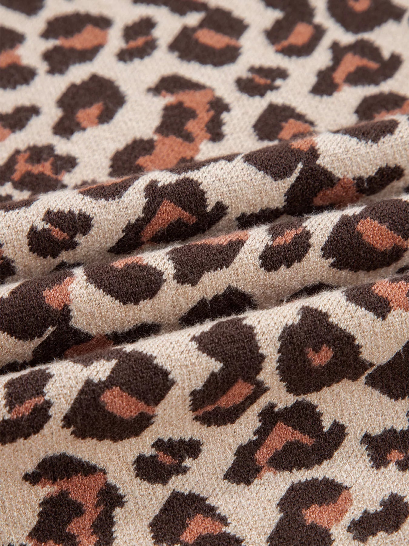 Close-up of leopard print fabric with brown, black, and beige colors.