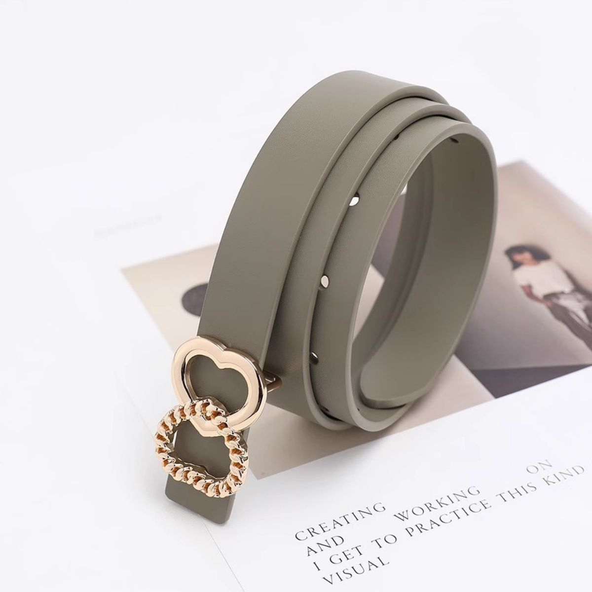 Gray belt with a gold heart-shaped buckle on a white background