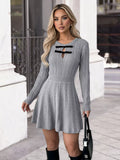 Woman wearing a gray ribbed dress with black accents in an urban setting.