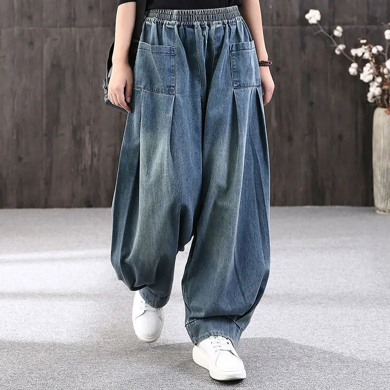 Model wearing blue denim wide-leg pants with white sneakers on a neutral background