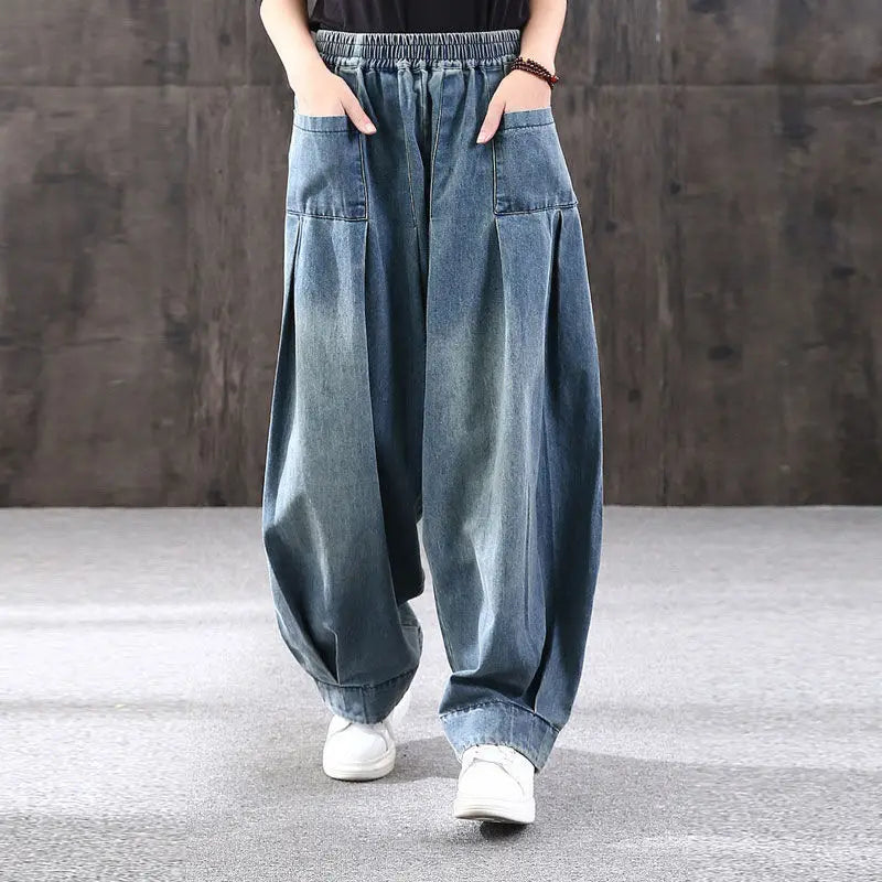 Model wearing blue denim wide-leg pants against a gray background