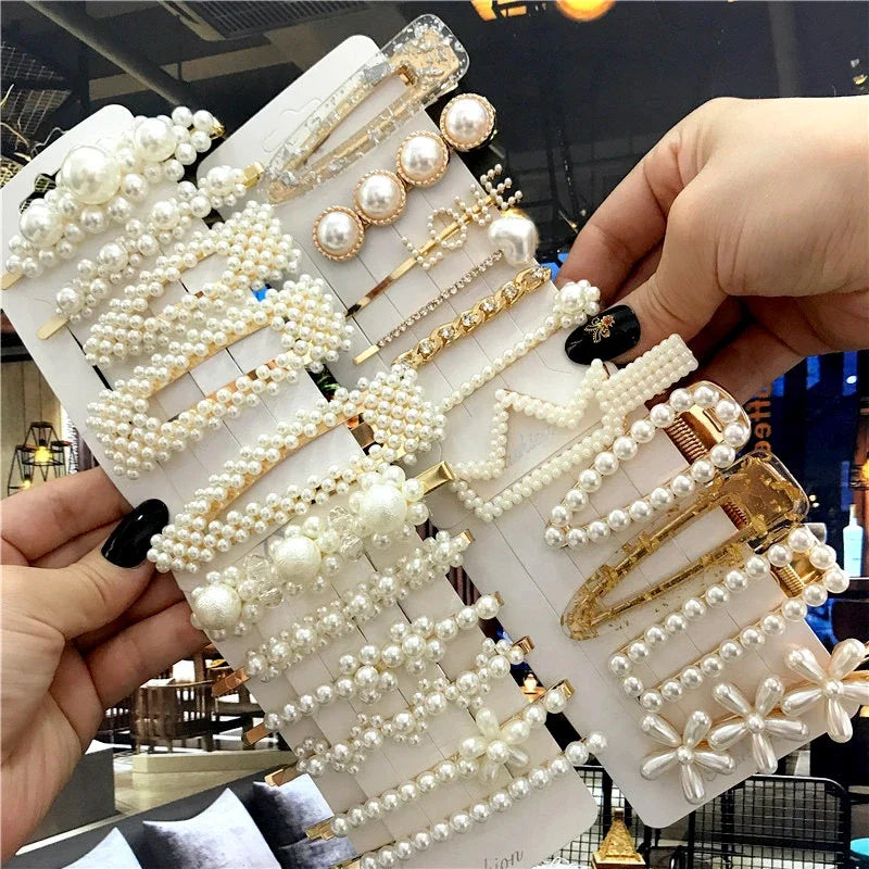 Set of pearl and gold hair accessories on a card held by a person.