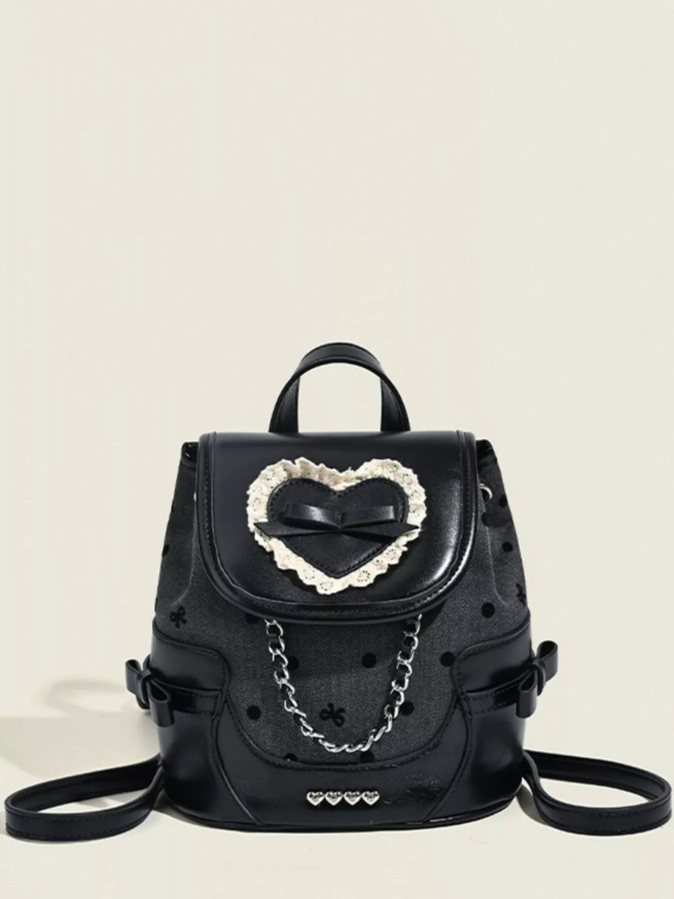 Black backpack with a heart-shaped design on a beige background