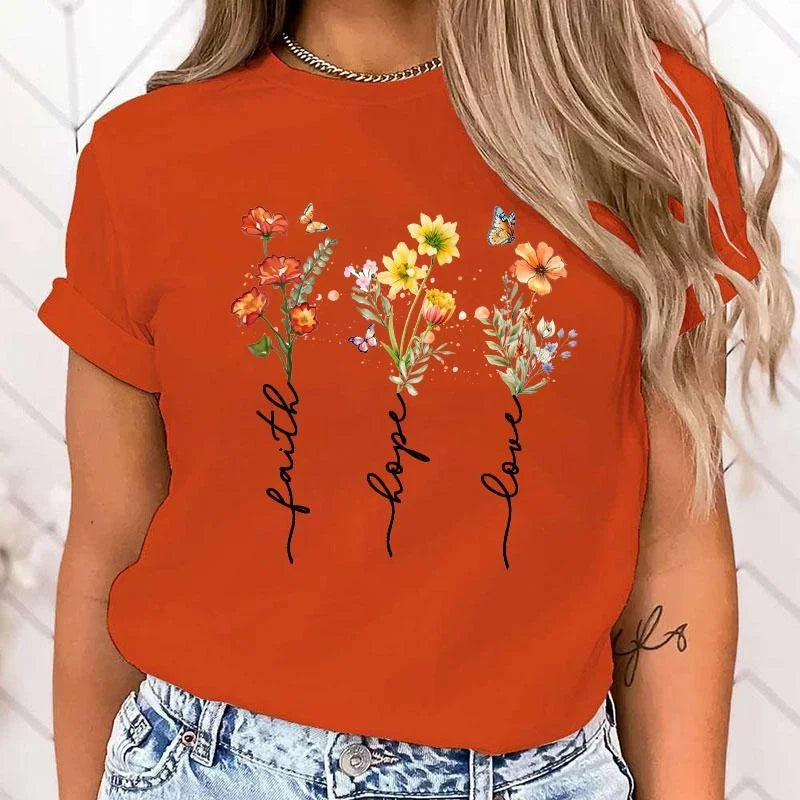 Person wearing an orange t-shirt with floral designs and text on a white background