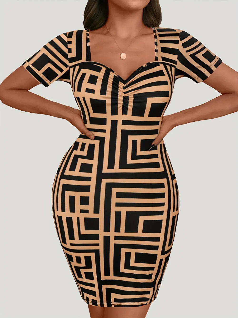 A woman modeling a short-sleeve bodycon dress with a black and beige geometric maze-like pattern, photographed against a plain light gray studio background.