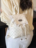 White polka dot backpack with lace details worn by a Model