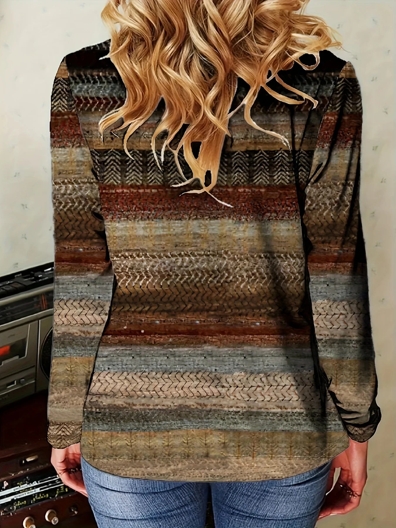 Person wearing a patterned sweater with a neutral background