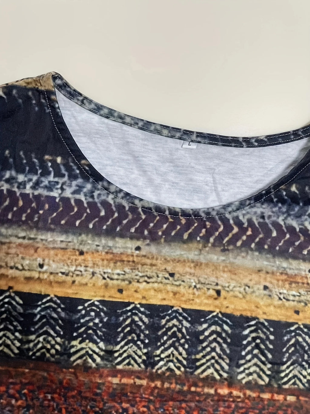 Close-up of a patterned fabric with a mannequin wearing it against a plain background