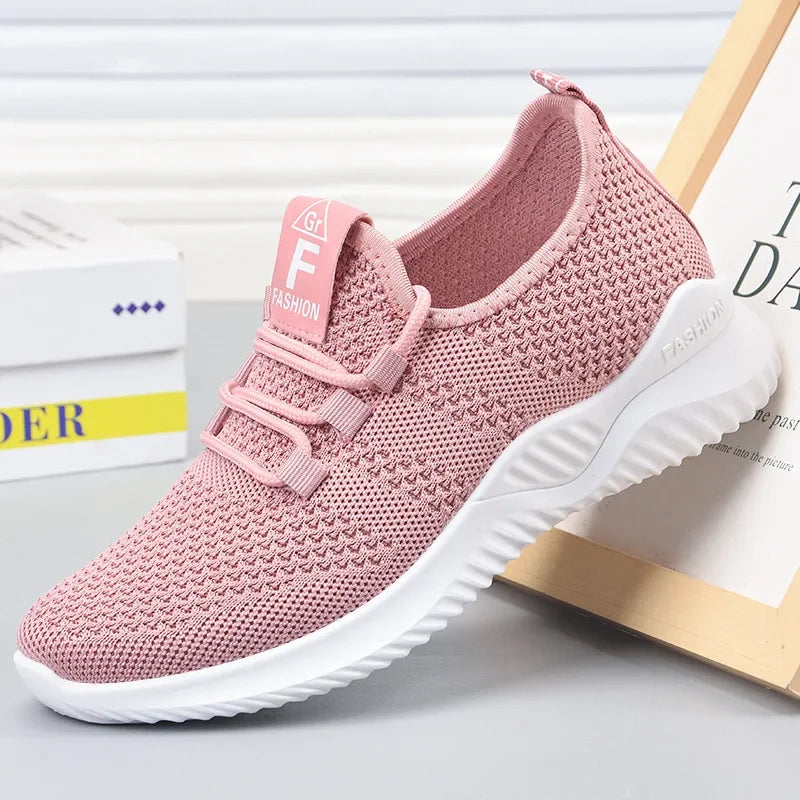 Pink athletic shoe with white sole on a light gray background