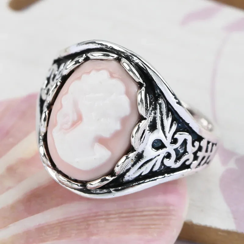 Silver ring with a pink cameo on a hand