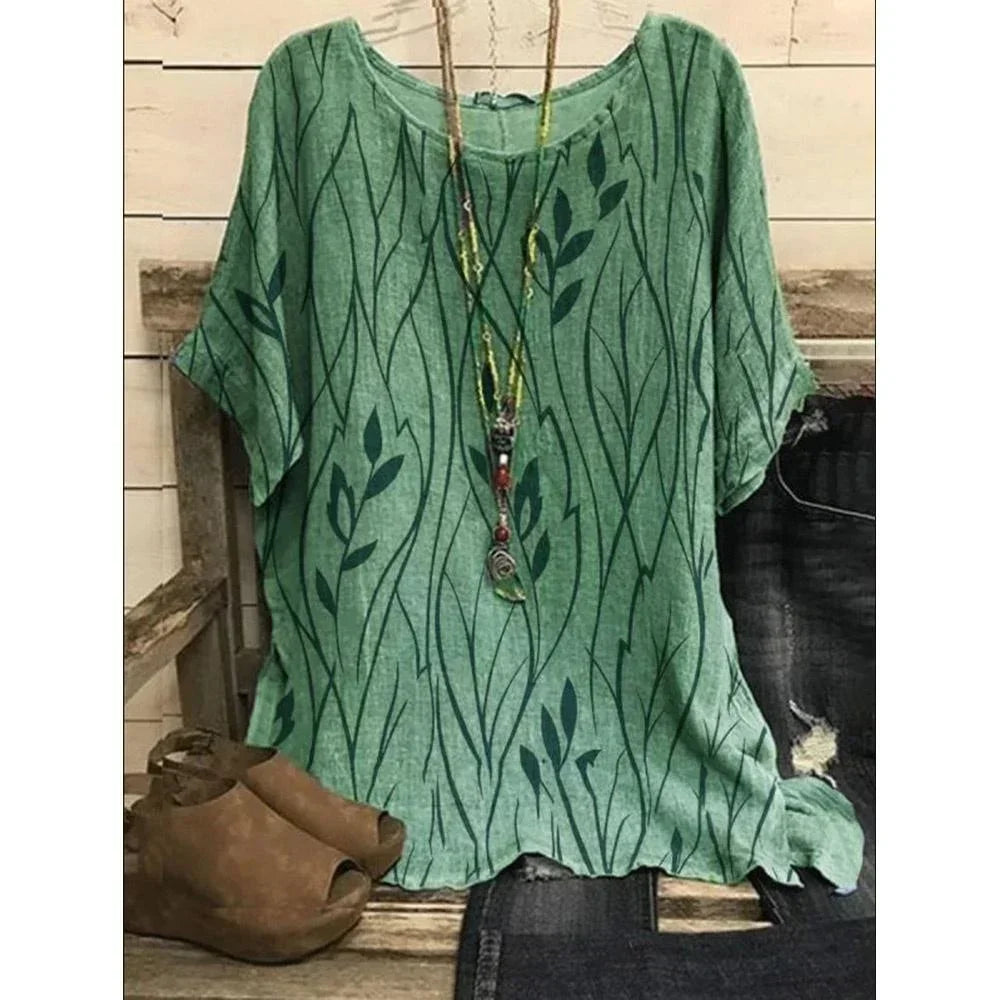 Green patterned shirt on a wooden bench with a brown bag and black pants.