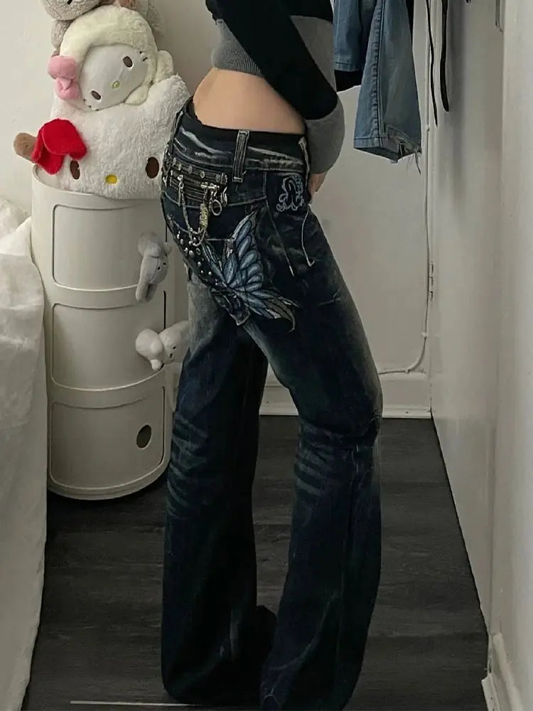 Model wearing embellished dark blue jeans standing in a room with a laundry basket and stuffed toy.