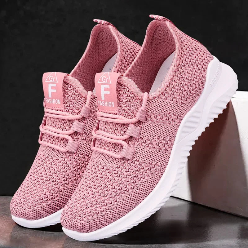 Pink sneakers with white soles on a dark background