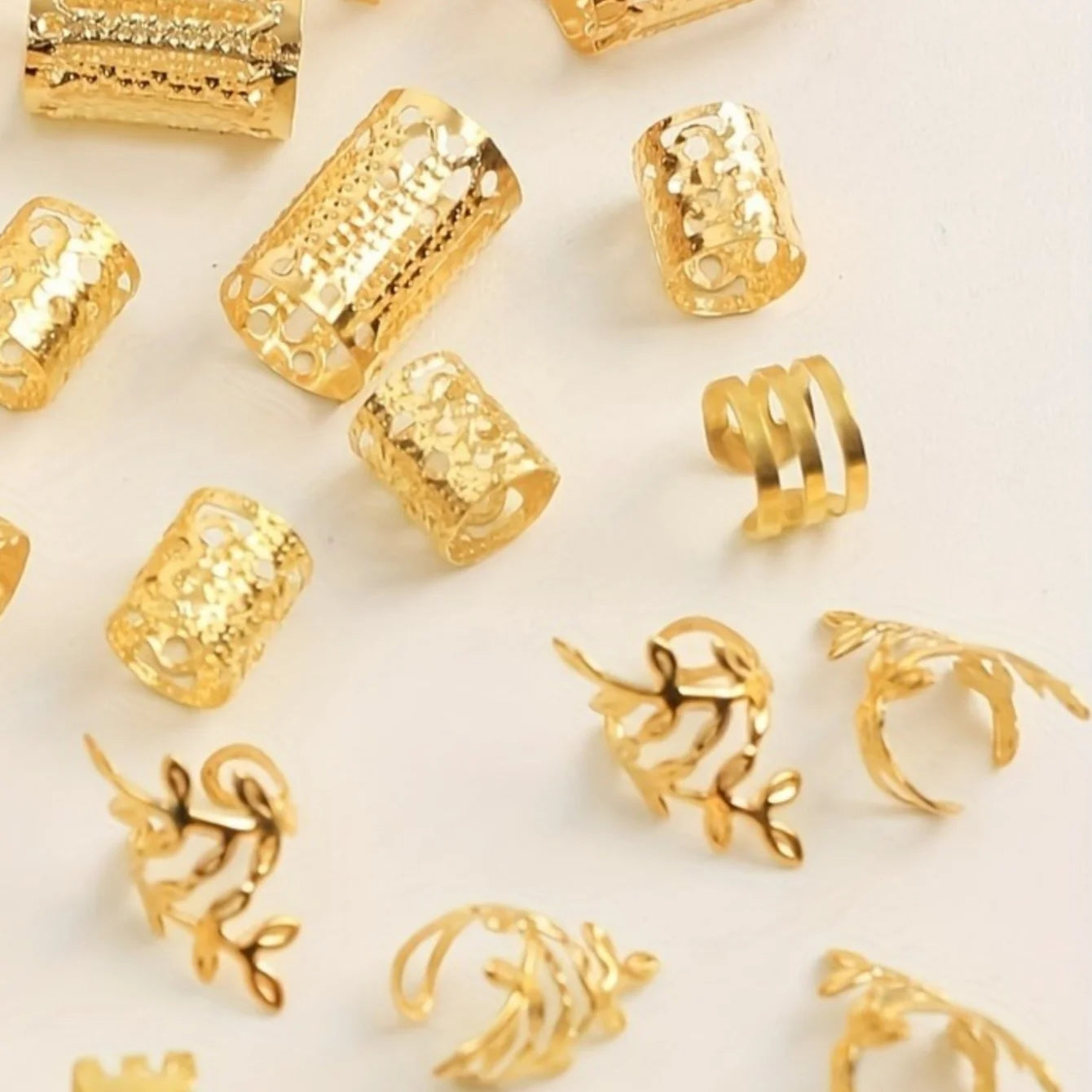 Gold rings with various designs on a light beige background