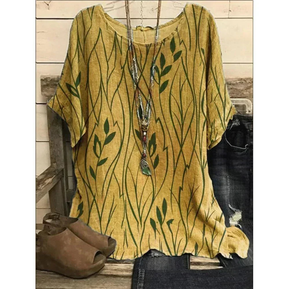 Yellow blouse with green leaf pattern on a wooden surface
