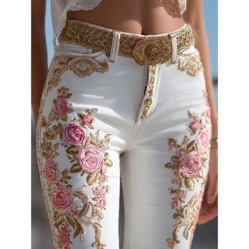 White pants with floral and gold embroidery and a decorative belt.