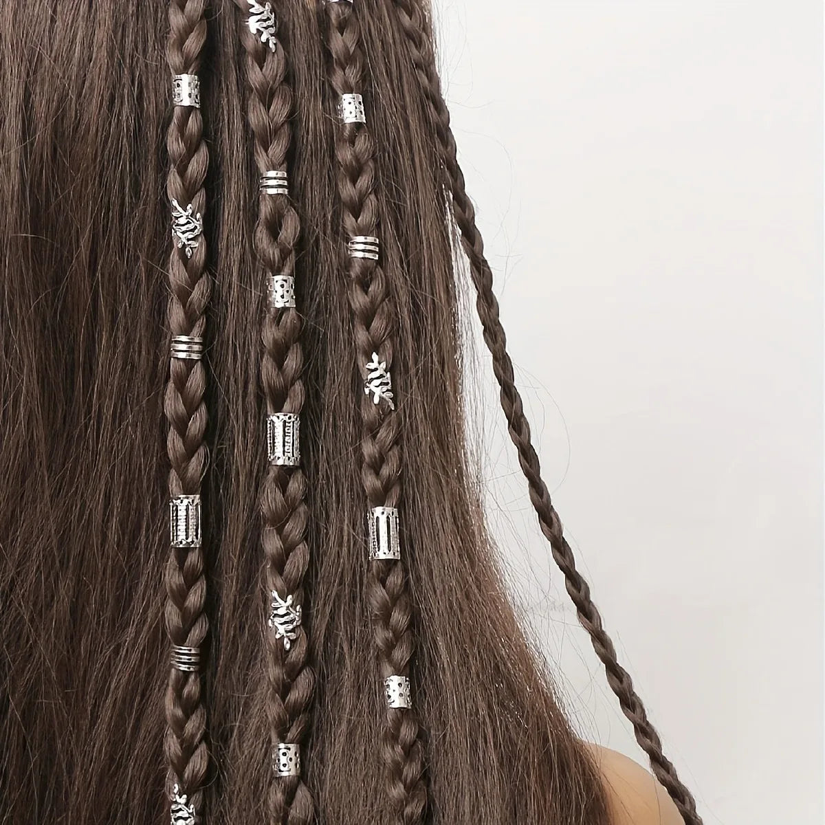 Close-up of braided hair with decorative beads on a white background