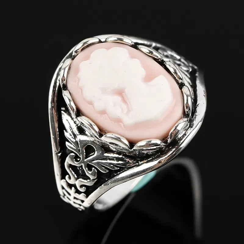 Silver ring with a pink Cameo stone on a black background