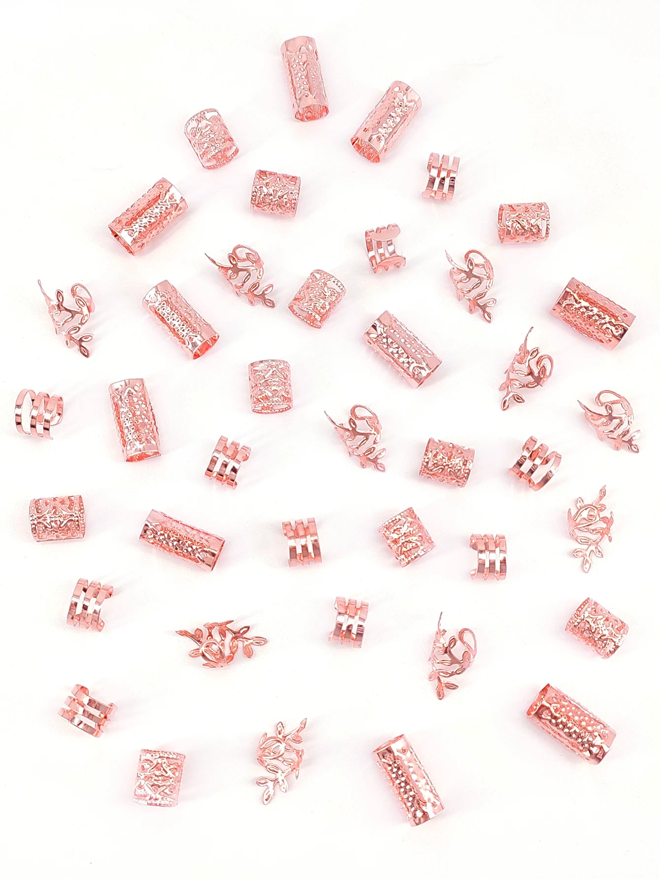 Collection of rose gold jewelry charms on a white background