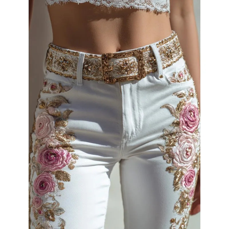 White jeans with floral and gold embroidery on a plain background