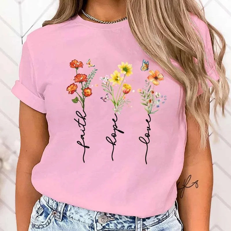 Person wearing a pink t-shirt with floral designs and text on a white background