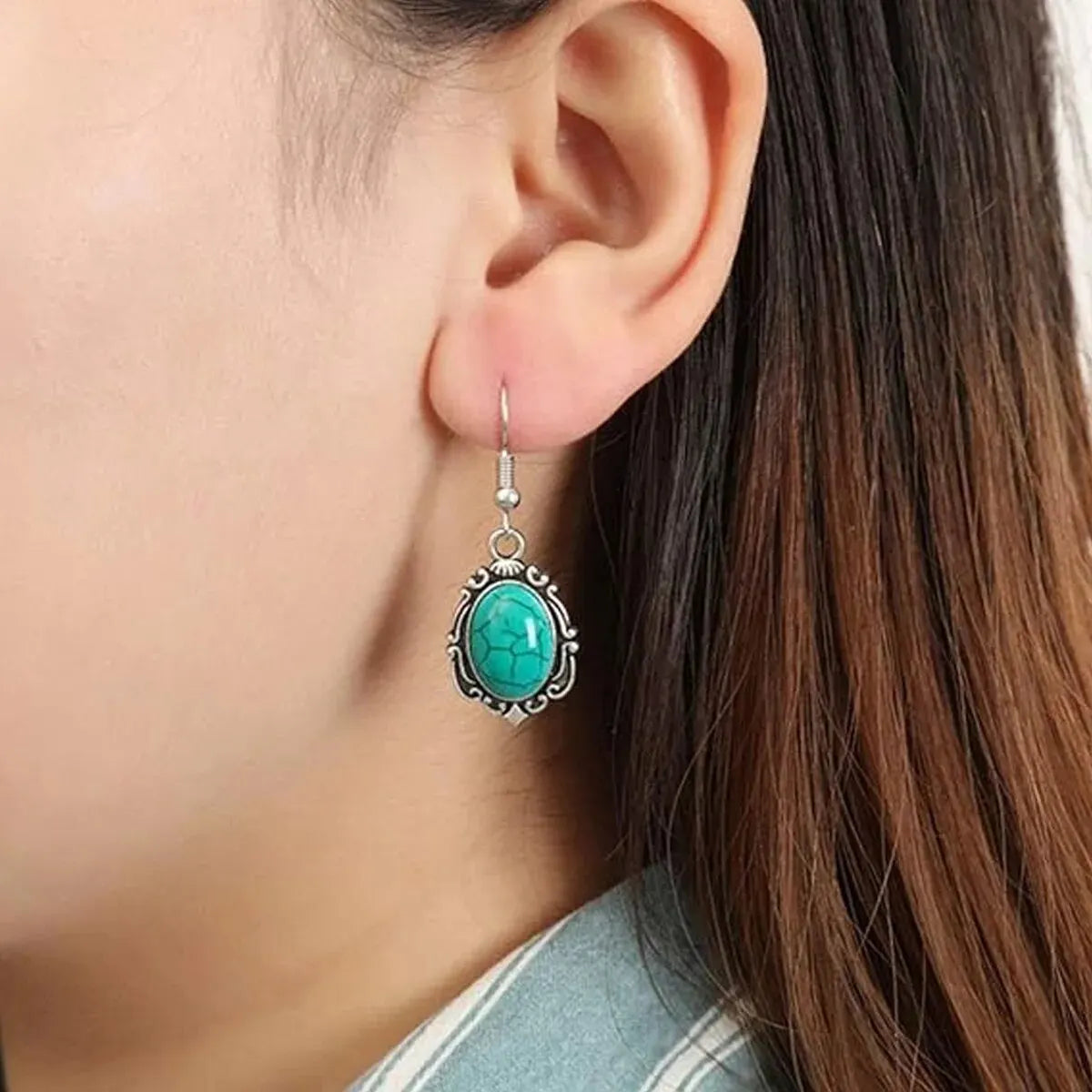 Close-up of a turquoise earring worn by model.