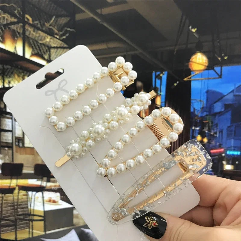 Pearl hair clips on a card held by a hand with a blurred background