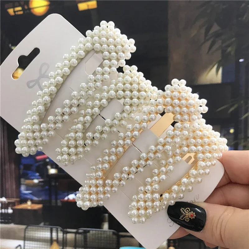 Pearl hair tie set on a card held by a hand with a blurred background