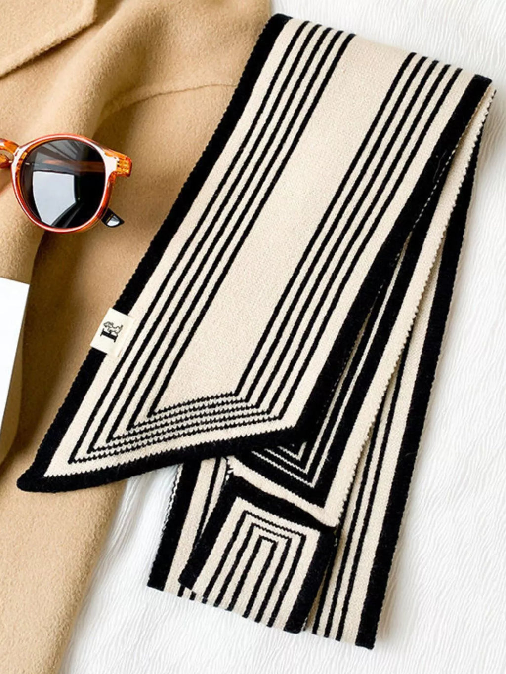 Black and white striped scarf with sunglasses on a white background