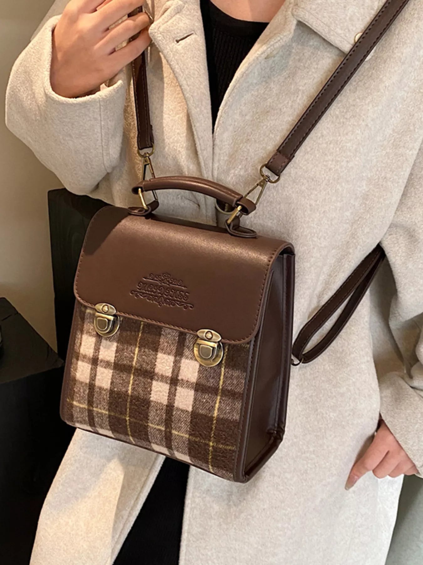 Model wearing a brown plaid handbag with gold accents