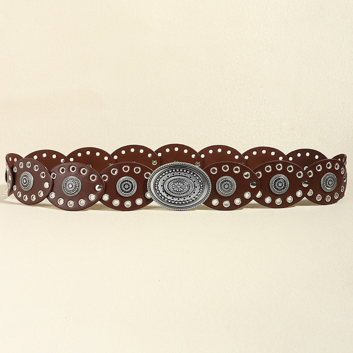 Brown belt with decorative silver buckle on a beige background