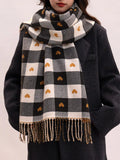 Model wearing a black and white checkered scarf with heart patterns on a plain background