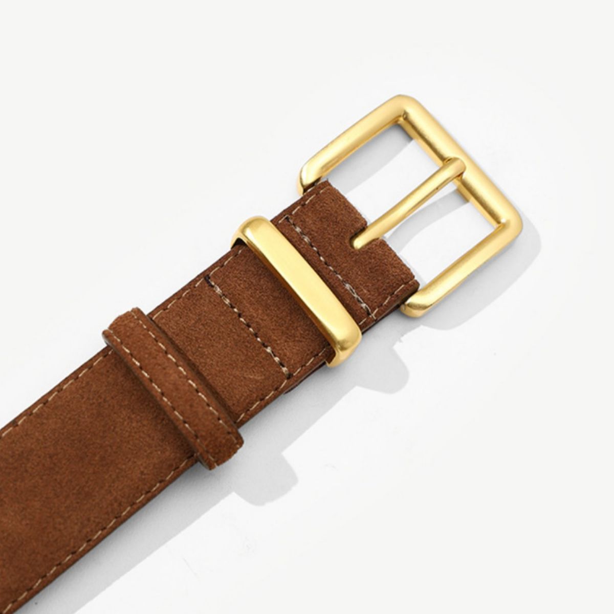 Brown leather watch strap with gold buckle on a white background