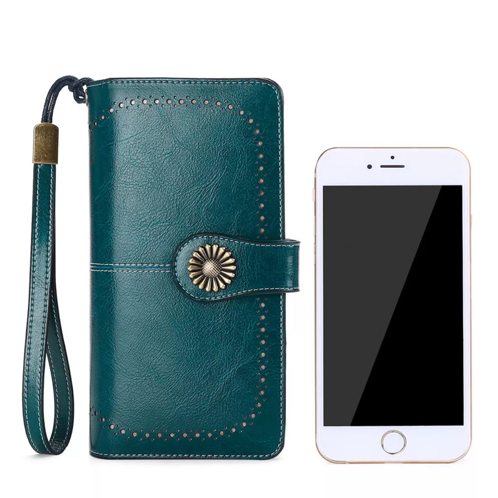 Teal wallet case with decorative button and strap next to a smartphone on a white background