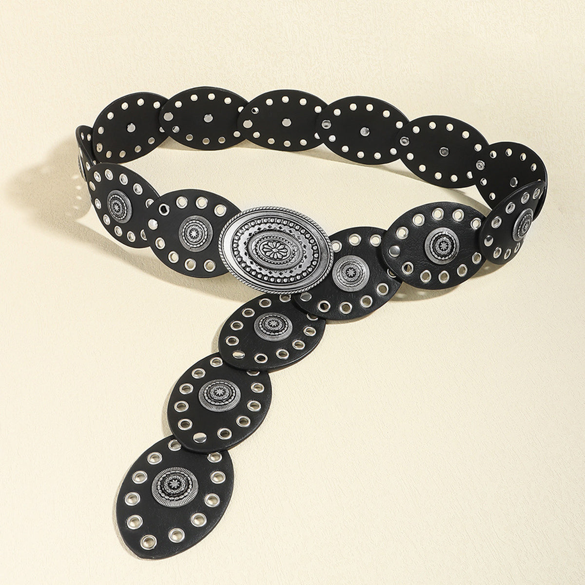 Black belt with silver circular patterns on a beige background