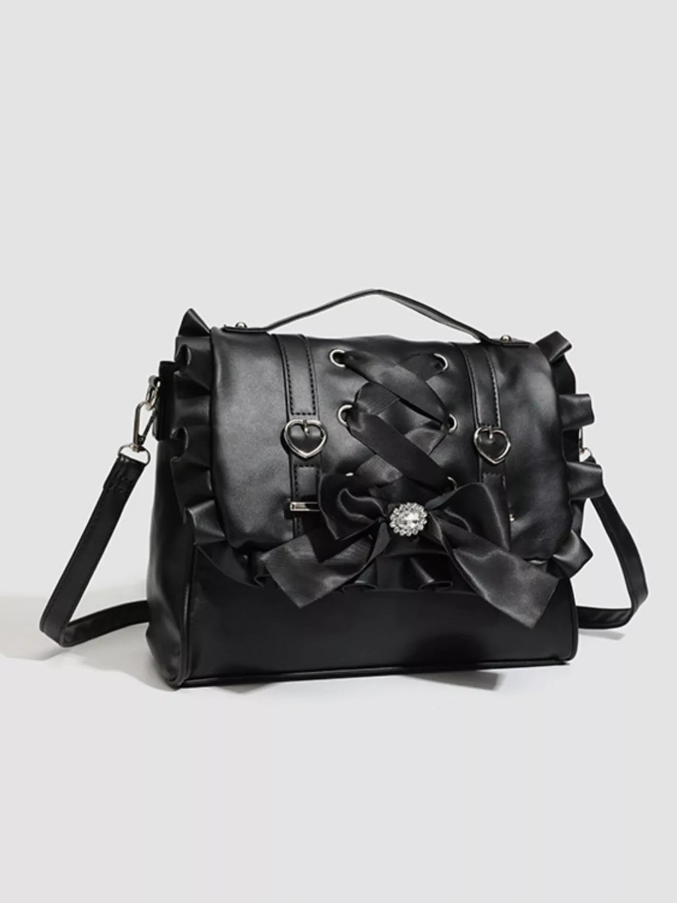 Black handbag with decorative bows on a light gray background