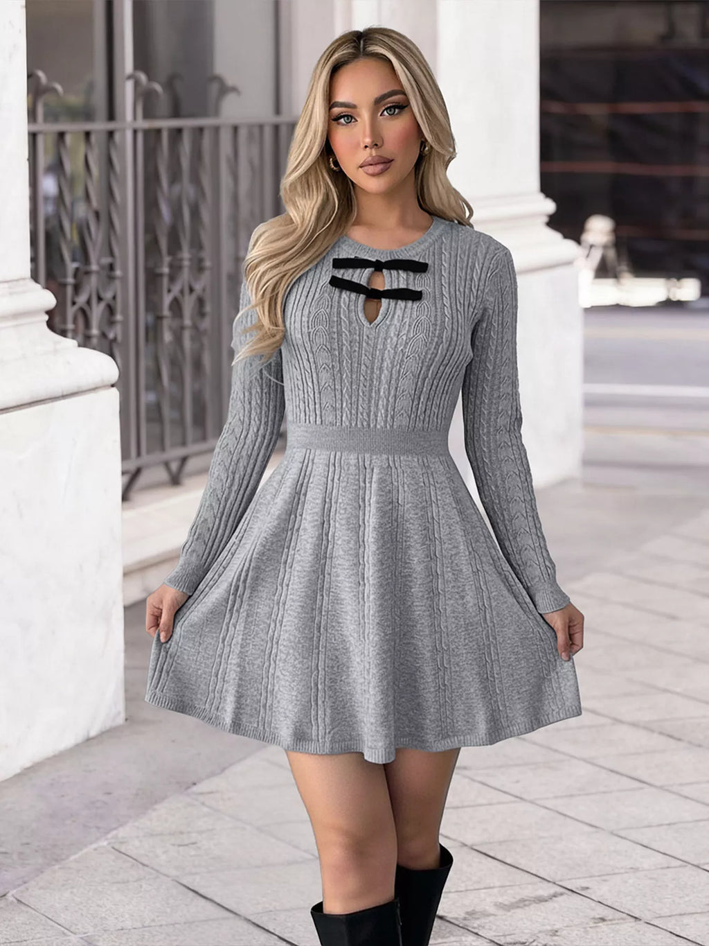 Woman wearing a gray knit dress with black accents in an urban setting.